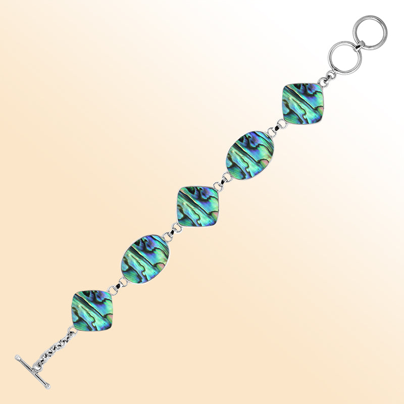 Handcrafted silver bracelet with oval and square abalone shell links in ocean-inspired design.