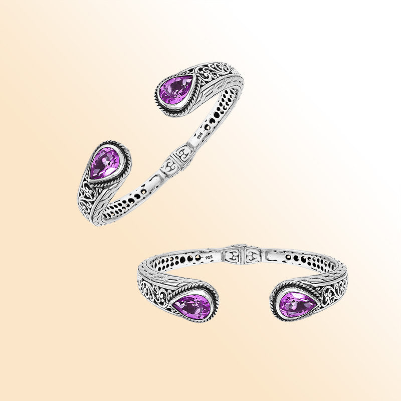 Handcrafted sterling silver bangle with teardrop amethyst quartz stones, intricate Bali engraving, polished shine, and a secure hinge lock for elegant everyday wear.