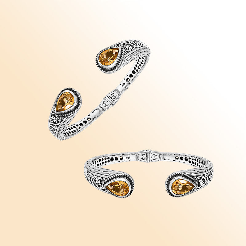 Handcrafted sterling silver bangle with teardrop citrine quartz stones, ornate Bali engraving, polished shine, and a secure hinge lock designed for elegant everyday wear.