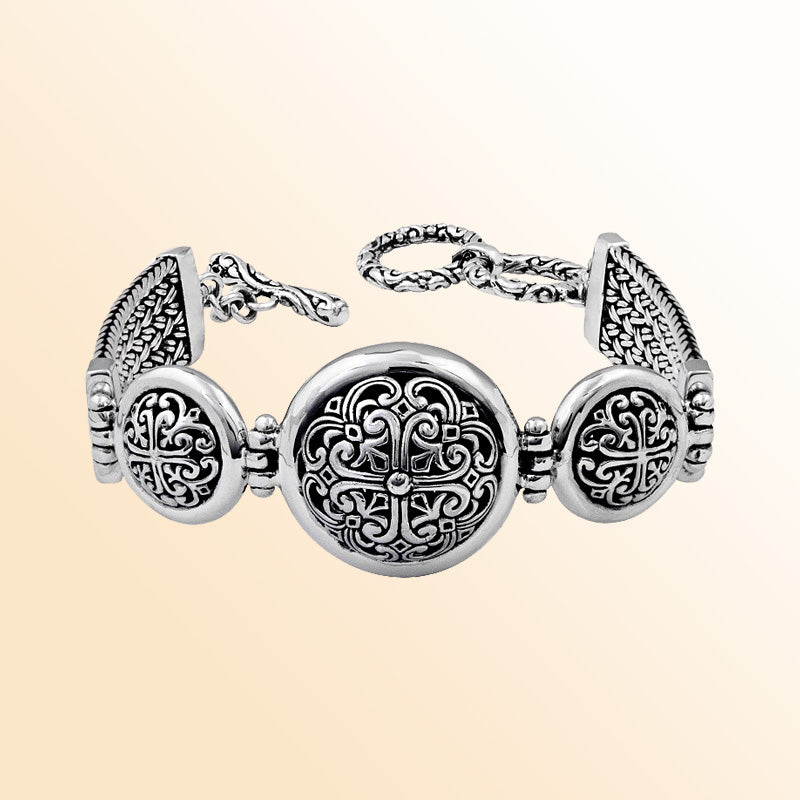 Sterling Silver artistic bracelet with round scrollwork panels, polished dome edging, and a smooth toggle closure reflecting elegant Balinese-inspired craftsmanship.
