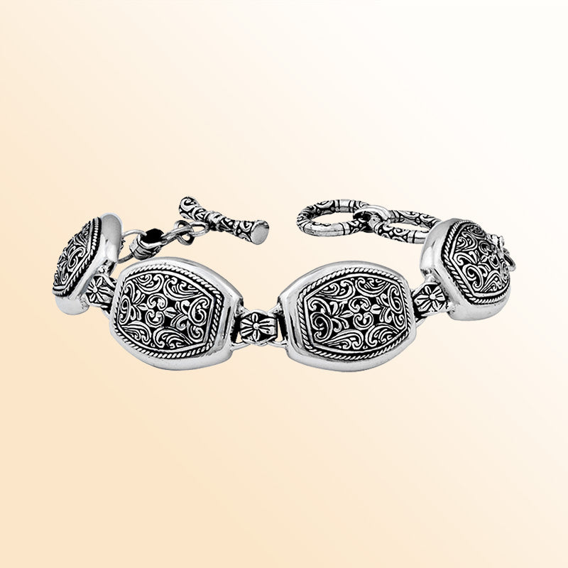 A stunning 925 sterling silver bracelet showcasing ornate handcrafted Balinese engravings, polished curved links, and a stylish toggle clasp for a refined, elegant appearance.