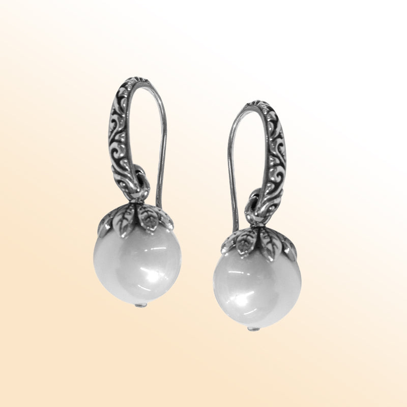 Sterling silver artisan Shell Pearl drop earrings with ornate leaf-cap detailing and earwire lock.