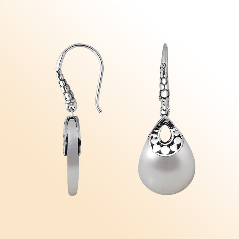 Handcrafted sterling silver Mother Of Pearl pear-drop earrings with antique oxidized finish and elegant Balinese design.