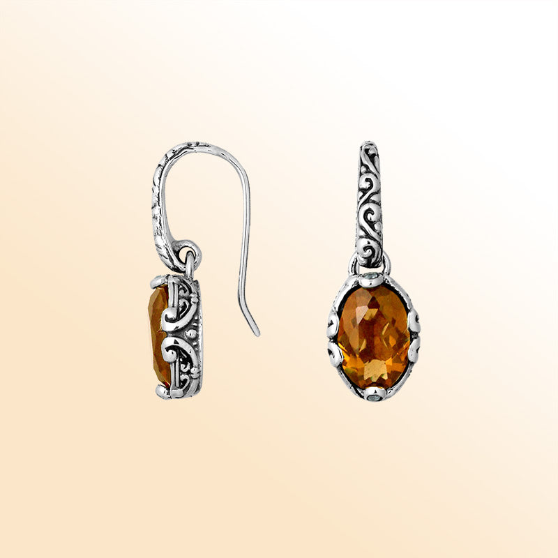 Artisan sterling silver earrings with glowing oval Citrine Quartz and ornate scroll detailing.