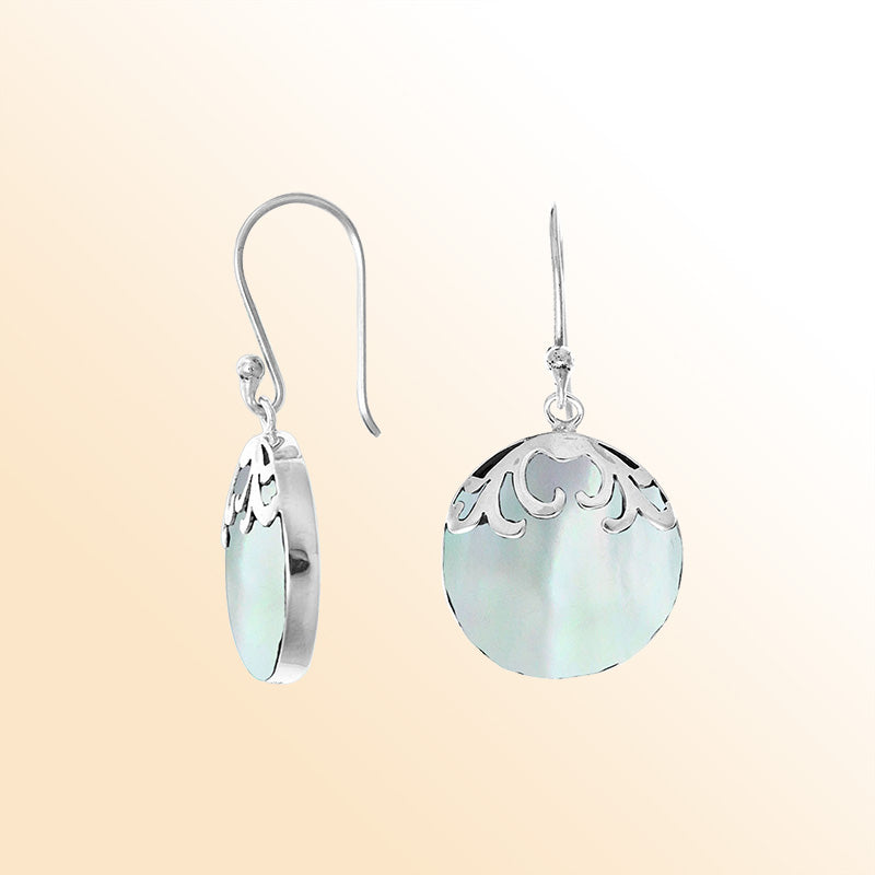 Beautiful sterling silver earrings featuring luminous round Mother of Pearl drops with detailed filigree accents and earwire hooks, handcrafted with artisan skill in Bali.