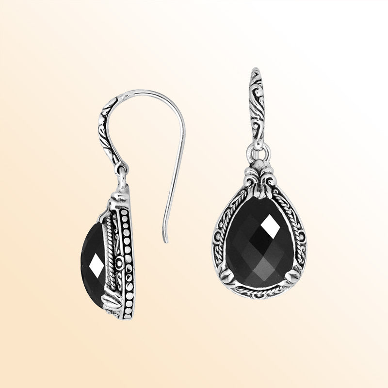 Sterling silver earrings featuring a striking faceted Black Onyx teardrop surrounded by artistic carved detailing and earwire lock, offering bold contrast and handcrafted contemporary elegance for expressive everyday wear.