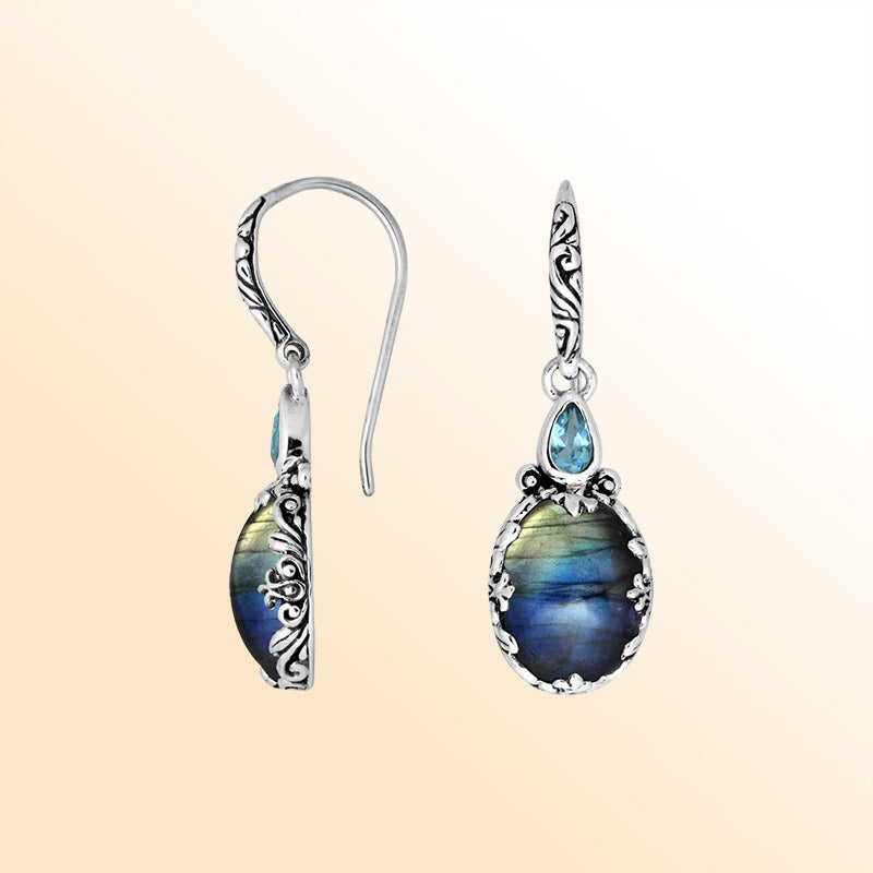 Sterling silver earrings featuring an iridescent Labradorite teardrop paired with a sparkling Blue Topaz Quartz accent, enriched with carved detailing and earwire lock for radiant, mystical everyday elegance.