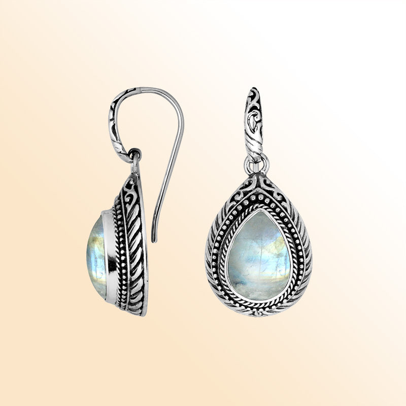 Sterling silver Rainbow Moonstone teardrop earrings with handcrafted carved silver frame, decorative bead accents, antique-polished finish, and elegant earwire hooks designed for refined everyday and special occasion wear.