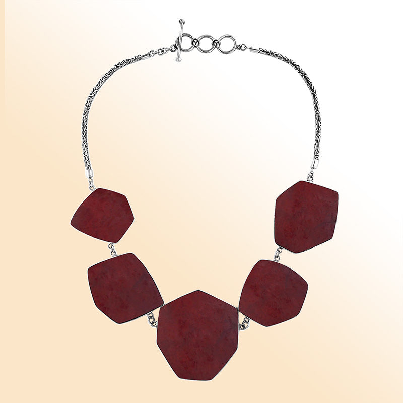 Handcrafted silver necklace with hexagon red coral links in elegant statement design.