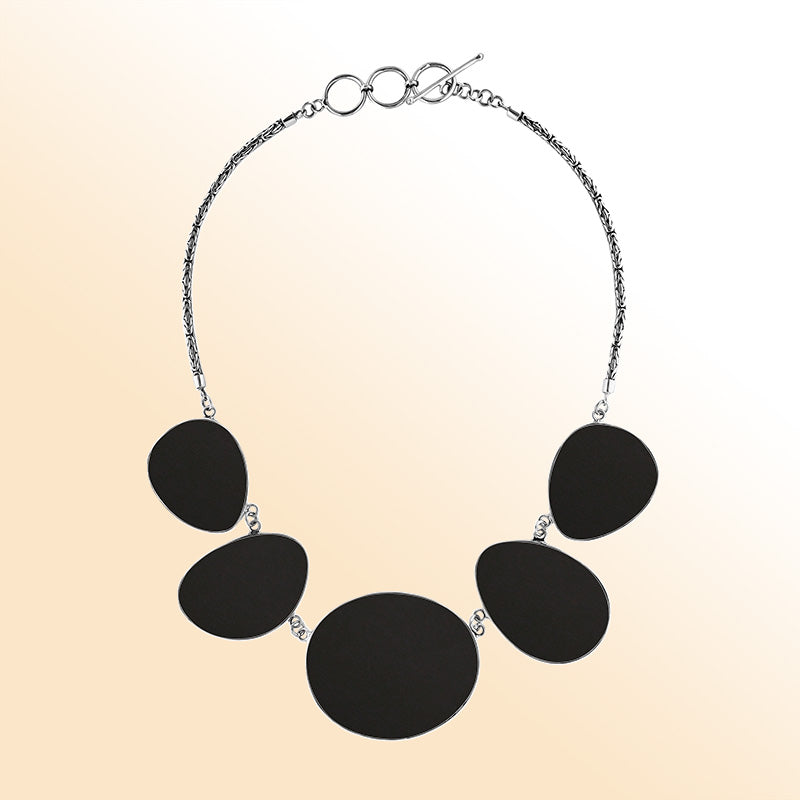 Handcrafted silver necklace with oval black shell links in bold artisan design.
