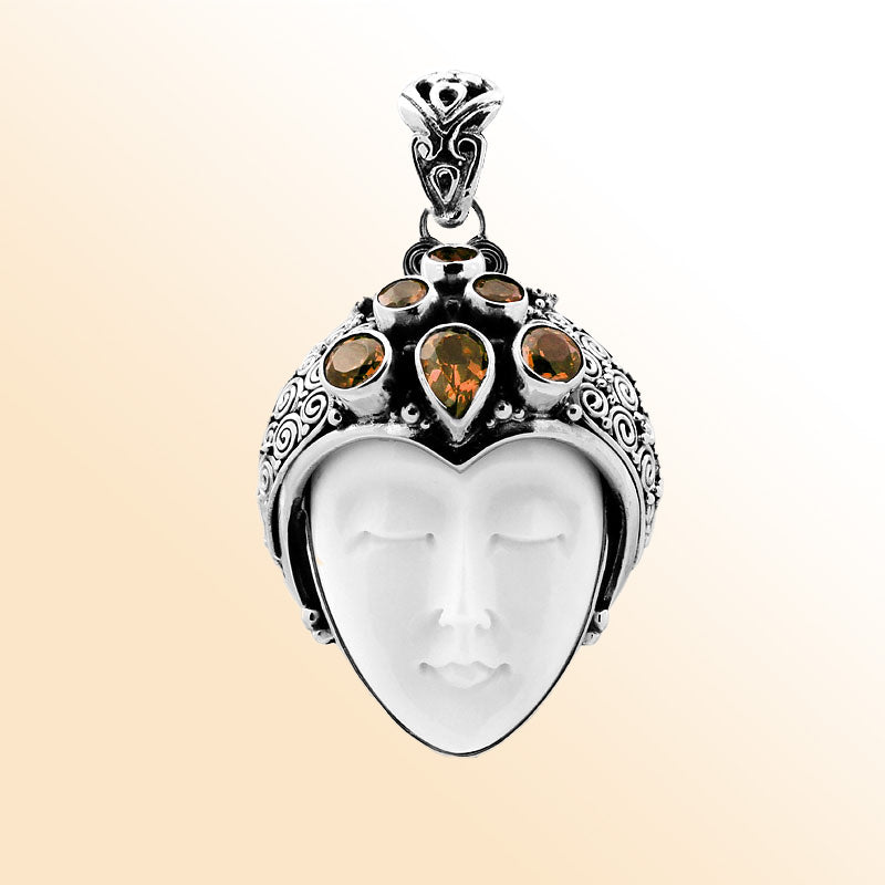 Handcrafted sterling silver pendant featuring a serene goddess face carved from bone with sparkling citrine gemstones, Balinese artisan jewelry for women.