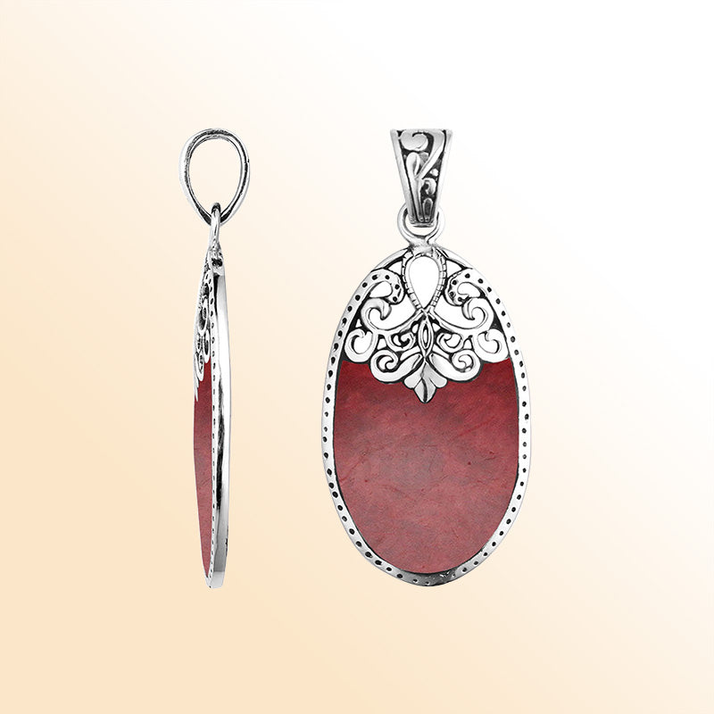 Sterling silver oval pendant with vibrant red coral inlay and delicate Balinese filigree design, handcrafted in Bali.