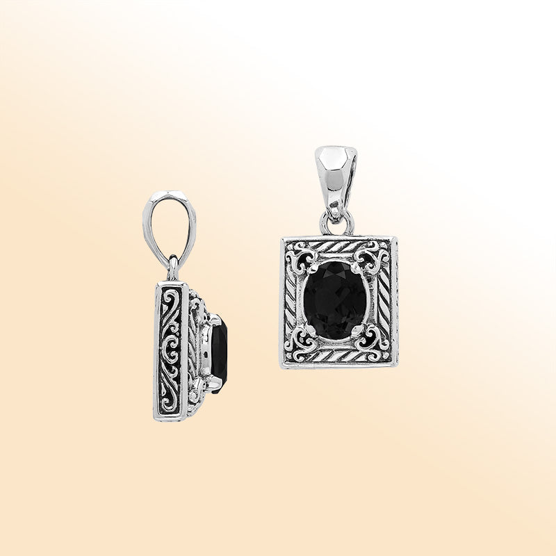 Handcrafted sterling silver pendant featuring oval black onyx quartz, ornate swirl engravings, and smooth polished finish showcasing modern Balinese artistry.