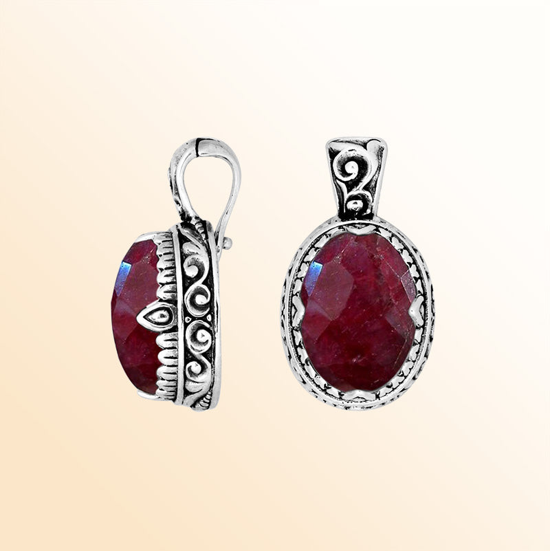 Handcrafted sterling silver pendant featuring a deep Ruby Quartz centerpiece surrounded by artistic Balinese scroll carvings and a smooth decorative frame for expressive personal styling.