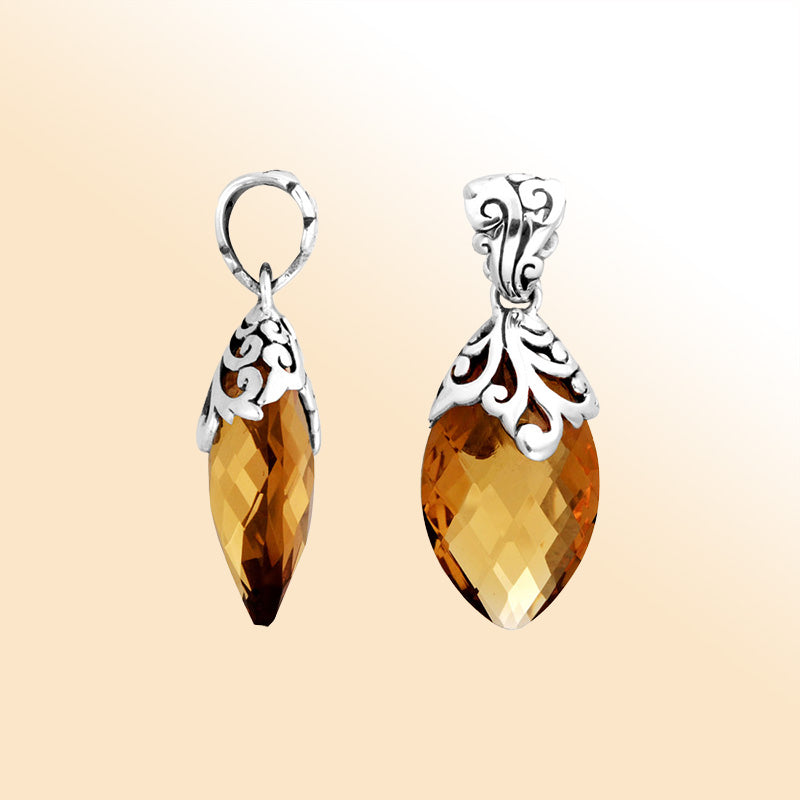 Handcrafted sterling silver marquise pendant featuring a faceted Citrine Quartz centerpiece surrounded by artistic Balinese filigree carvings and a polished decorative frame.