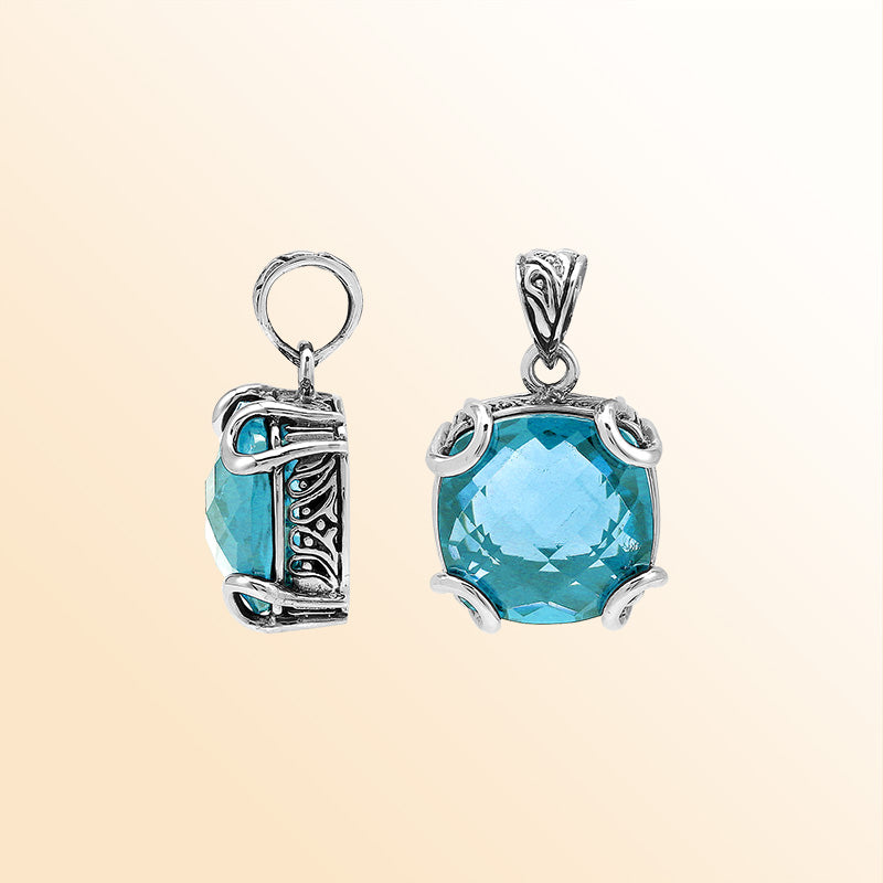 Handcrafted sterling silver cushion pendant featuring a faceted Blue Topaz Quartz centerpiece highlighted by artistic prong work and Balinese carved detailing.
