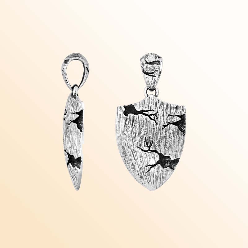Artistic sterling silver shield-shaped pendant featuring engraved running deer motifs with textured surface and polished detailing for modern nature-inspired jewelry styling