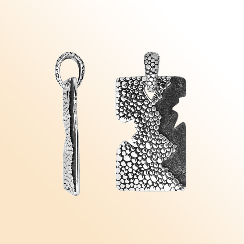 Artistic sterling silver rectangle pendant with cracked divider and pebble texture.