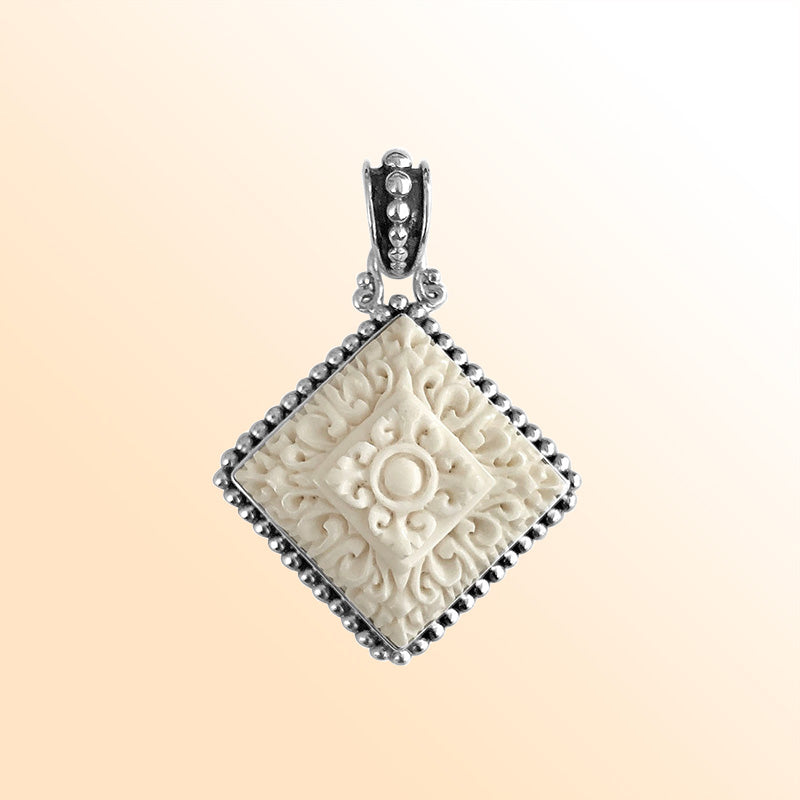 Artistic sterling silver square pendant with hand-carved bone centerpiece.