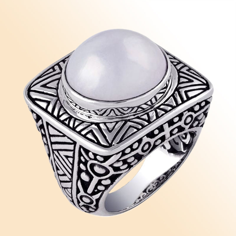 Sterling silver statement ring with a luminous white Mabe Pearl centerpiece, set on a bold square band with detailed Bali-inspired carvings.