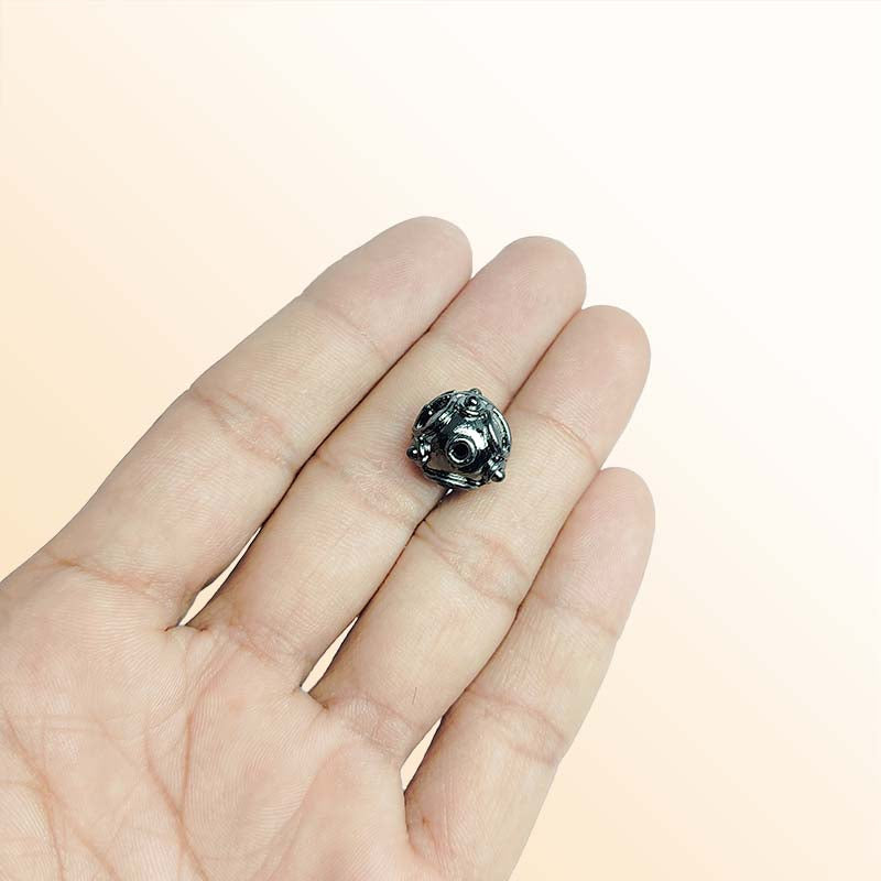 Handcrafted black rhodium overlay filigree bead over copper with spherical shape made in India.