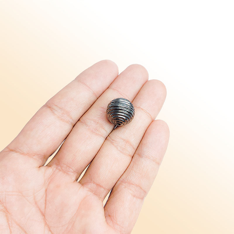 Handcrafted black rhodium overlay copper ribbed round charm from India with textured finish