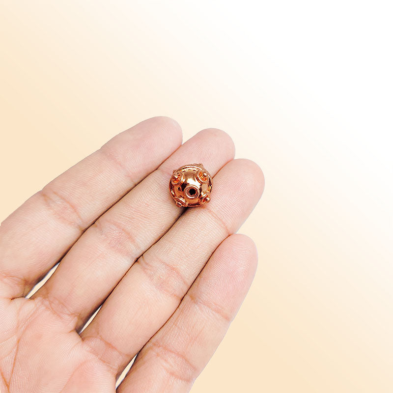 Handcrafted round Rose Gold bead from India featuring decorative swirl detailing for elegant jewelry designs
