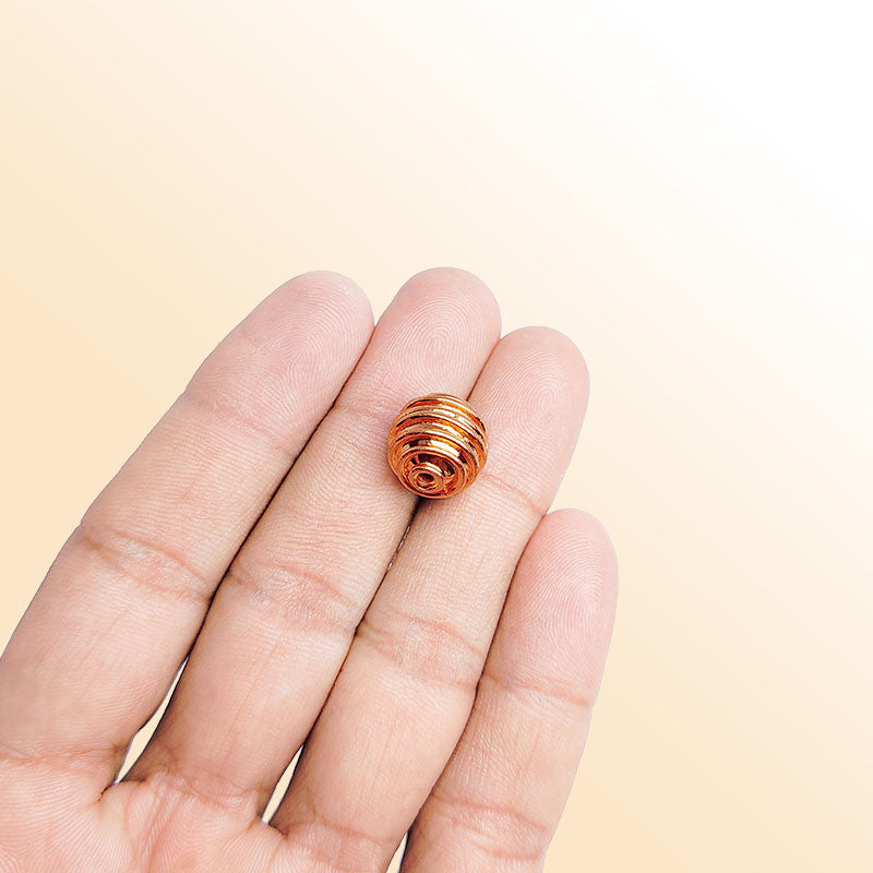 Rose gold ribbed copper bead handcrafted in India with polished finish and rounded shape