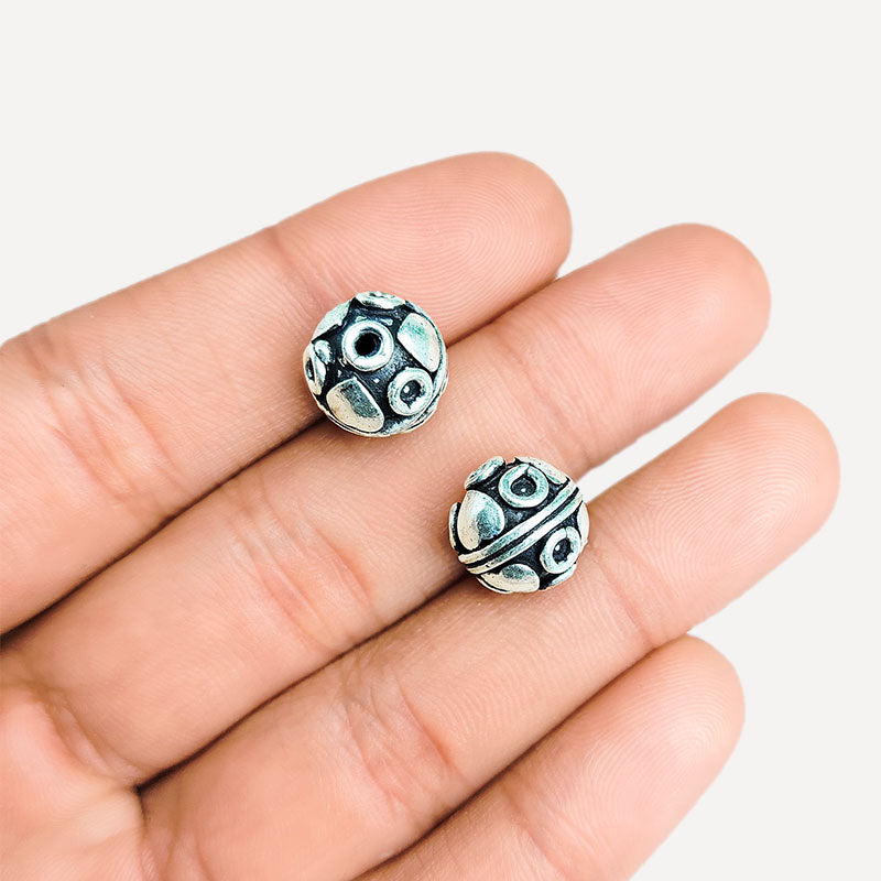 Studded silver overlay over copper round bead handcrafted in India with raised oval detailing