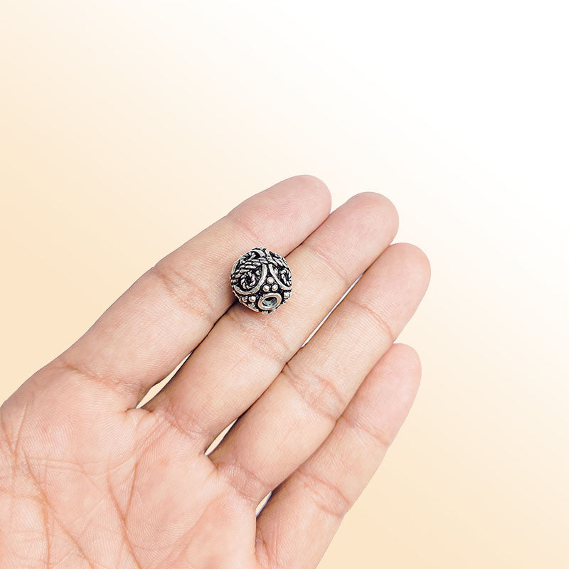 Artisan silver overlay over copper round bead with spiral scroll design, handcrafted in India for jewelry making.