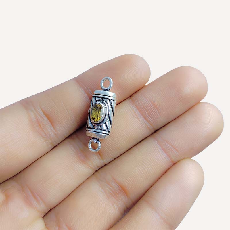 Polished silver overlay connector pendant with oval yellow stone crafted from silver overlay over copper in India.