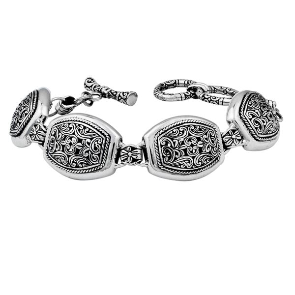 A stunning 925 sterling silver bracelet showcasing ornate handcrafted Balinese engravings, polished curved links, and a stylish toggle clasp for a refined, elegant appearance.