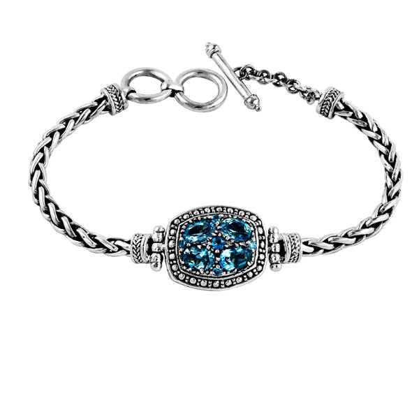 Sterling Silver artistic bracelet showcasing a Blue Topaz Quartz cluster centerpiece, intricately braided chain, and a polished toggle closure inspired by Balinese craftsmanship.