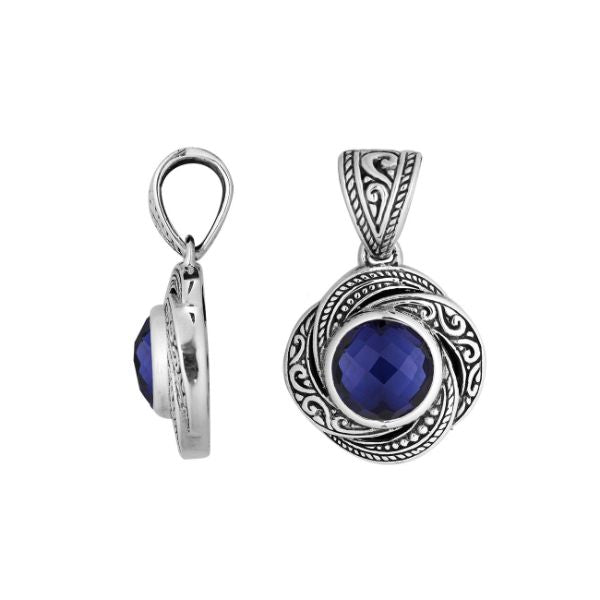 An elegant sterling silver pendant featuring a deep Sapphire Quartz set in swirling filigree, handcrafted with Balinese artistry to reflect timeless beauty and feminine grace.