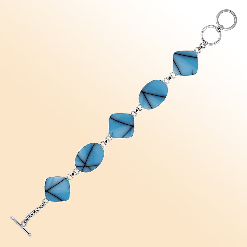 Handcrafted silver bracelet with turquoise shell oval and cushion links, artisan ocean-inspired design.
