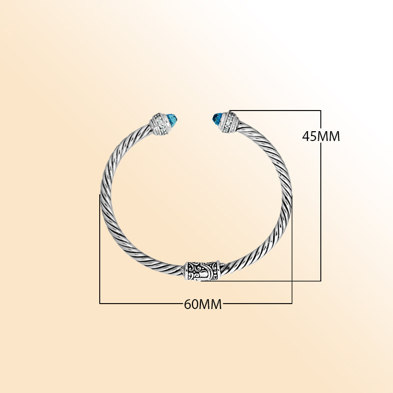 Handcrafted Bali sterling silver bangle featuring Blue Topaz Quartz and Cubic Zirconia, rope-style design with ornate motifs.