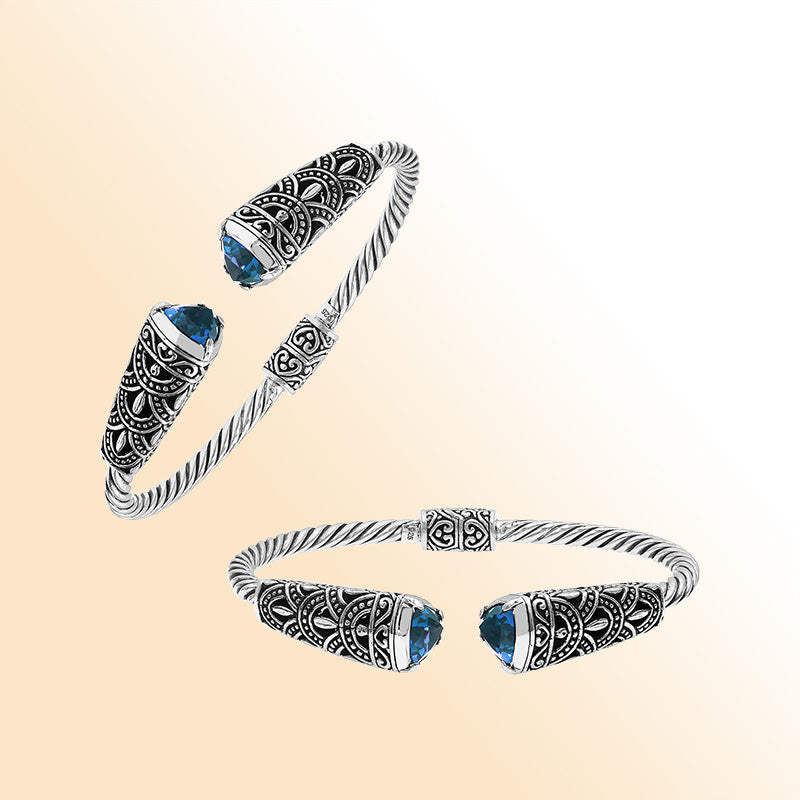 Elegant sterling silver open bangle with blue topaz quartz accents and Balinese detailing
