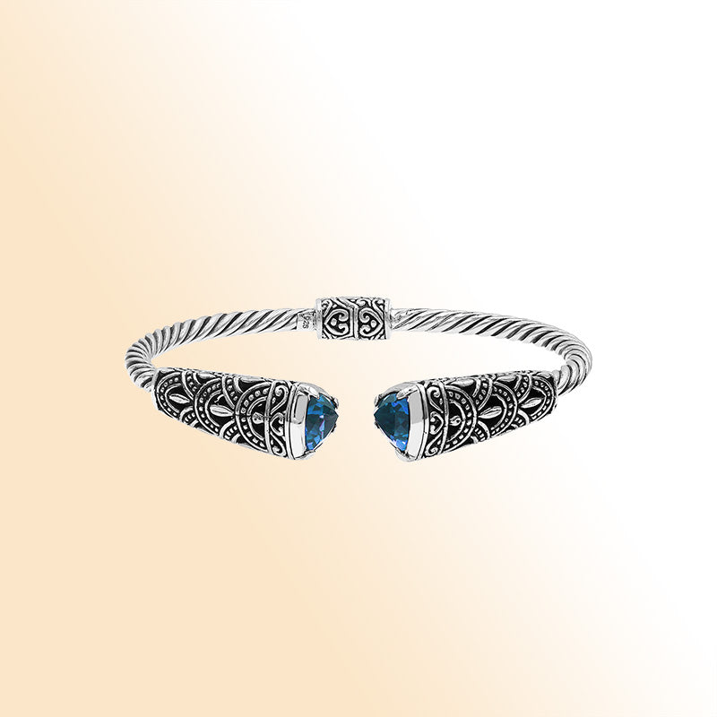 Elegant sterling silver open bangle with blue topaz quartz accents and Balinese detailing
