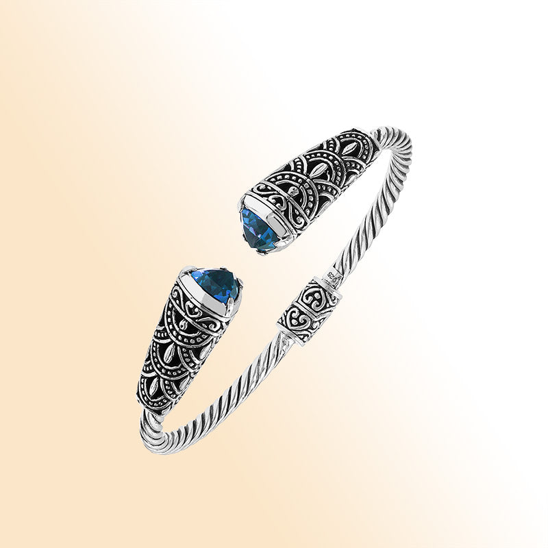 Elegant sterling silver open bangle with blue topaz quartz accents and Balinese detailing