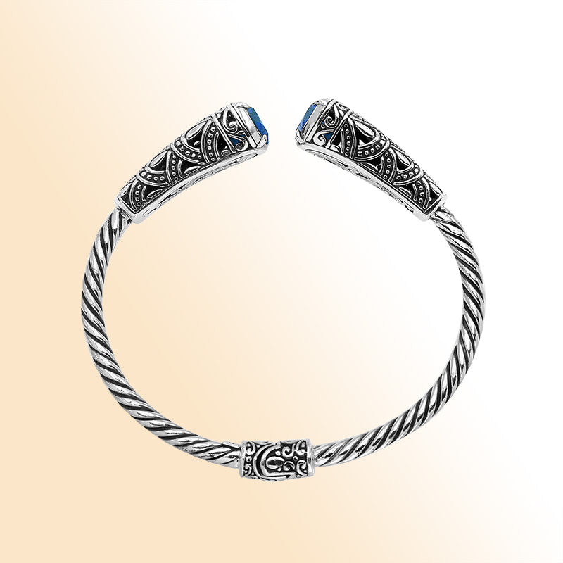 Elegant sterling silver open bangle with blue topaz quartz accents and Balinese detailing