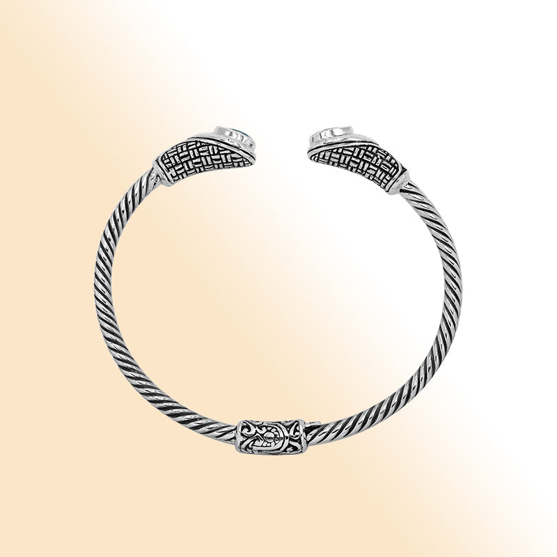 Sterling silver Balinese cuff bangle with Blue Topaz Quartz accents and ornate scroll design.