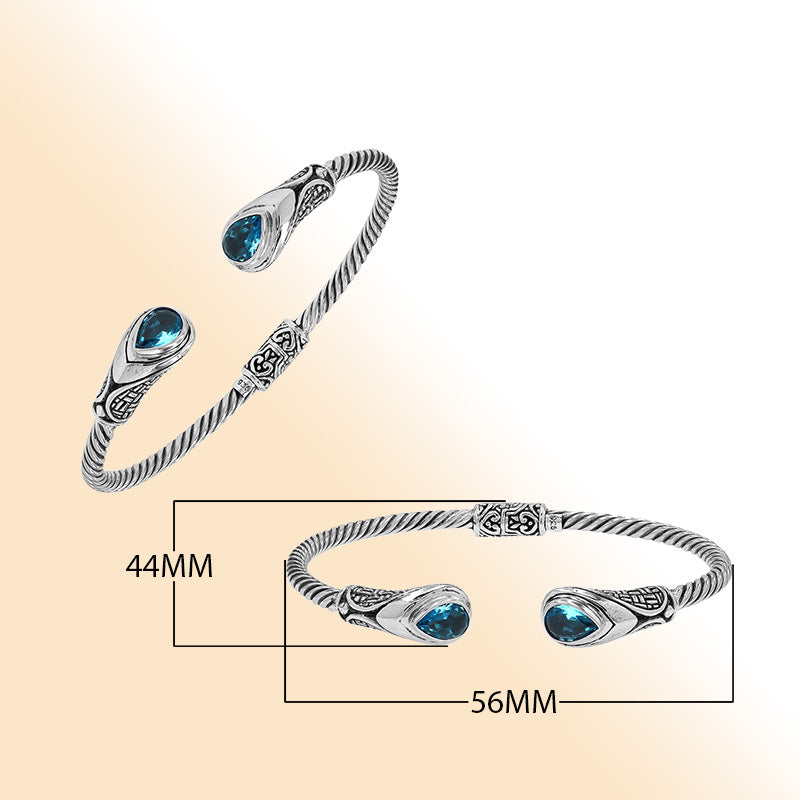 Sterling silver Balinese cuff bangle with Blue Topaz Quartz accents and ornate scroll design.
