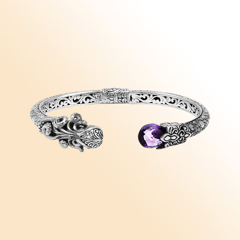 A handcrafted sterling silver octopus bangle featuring amethyst quartz, detailed tentacle carvings, oxidized Balinese textures, and a smooth hinge lock for elegant everyday or statement wear.