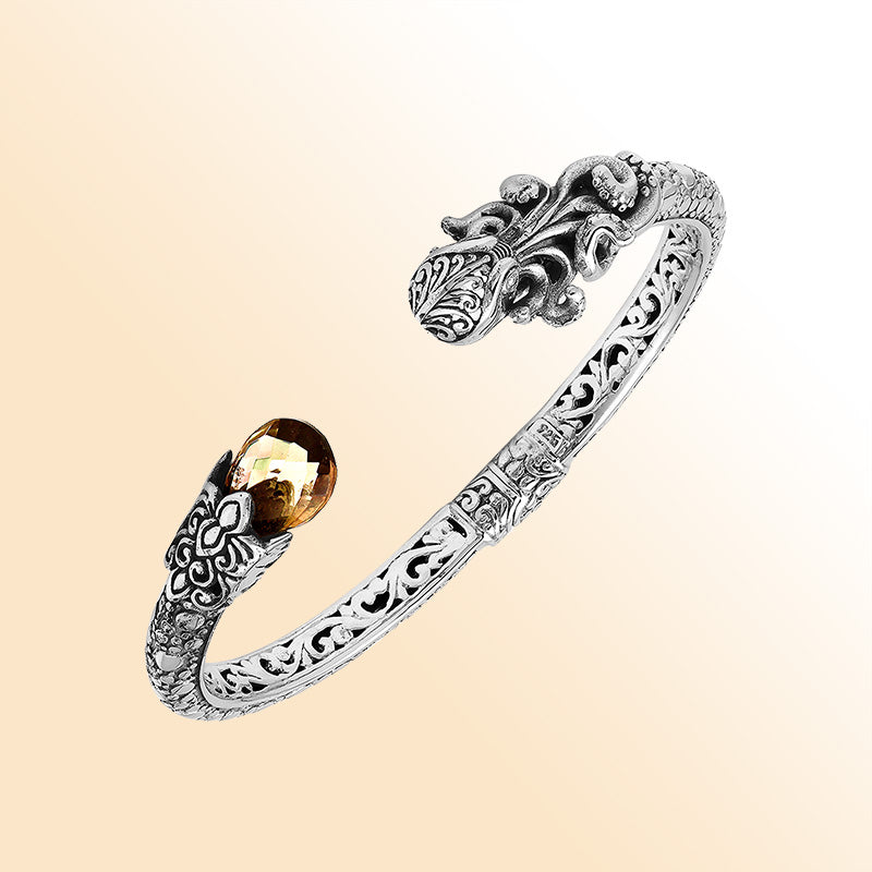 A handcrafted sterling silver octopus bangle featuring citrine quartz, ornate Balinese tentacle carvings, oxidized detailing, and a smooth hinge lock for stylish luxury wear.