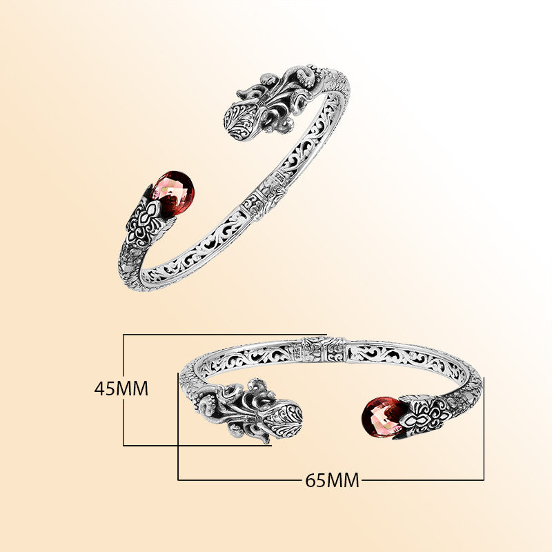 Handcrafted sterling silver dragon head cuff with garnet quartz ends and floral carvings made in Bali.