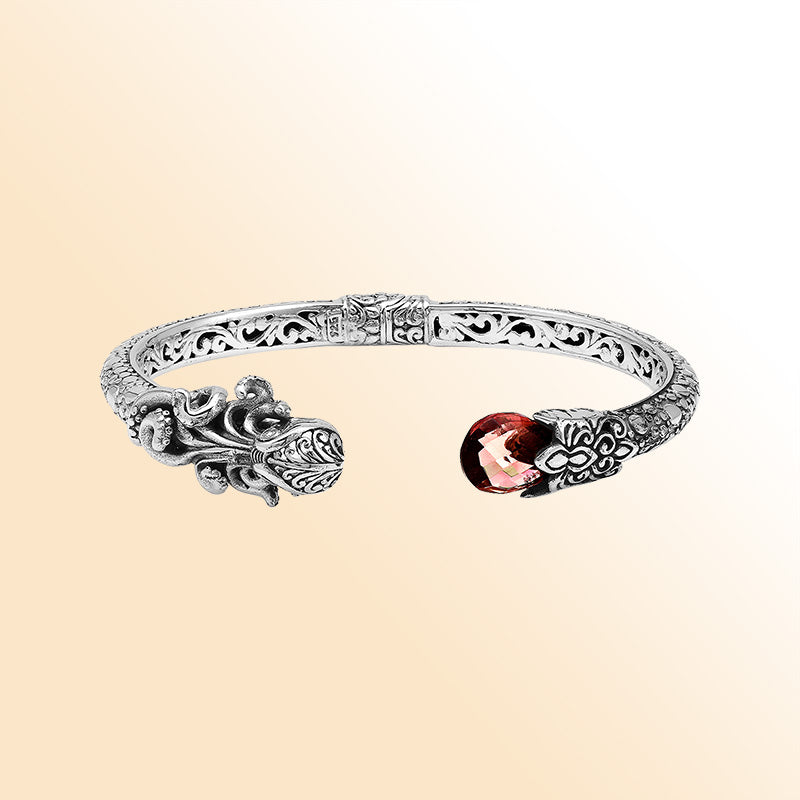 Handcrafted sterling silver dragon head cuff with garnet quartz ends and floral carvings made in Bali.
