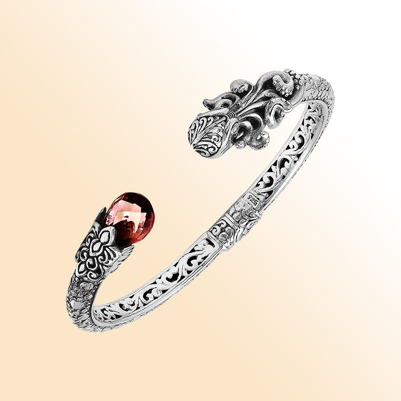 Handcrafted sterling silver dragon head cuff with garnet quartz ends and floral carvings made in Bali.