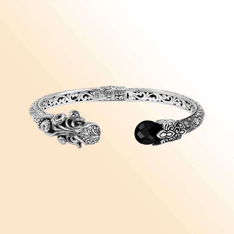 Handcrafted sterling silver dragon head cuff with black onyx ends and floral carvings made in Bali.