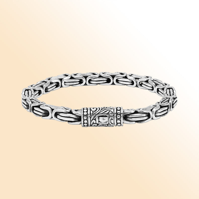 A handcrafted sterling silver bracelet featuring thick Balinese chain links, oxidized highlights, artistic metalwork, and a strong push clasp perfect for everyday luxury wear.