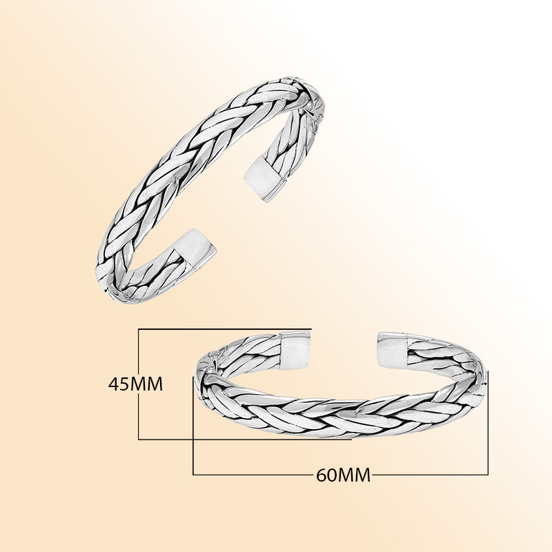 A handcrafted sterling silver large bangle featuring wide woven patterns, polished surfaces, and a secure hinge lock, designed for elegant everyday or statement wear.